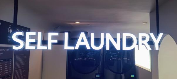 벽면에 설치된 SELF LAUNDRY 조명 사인